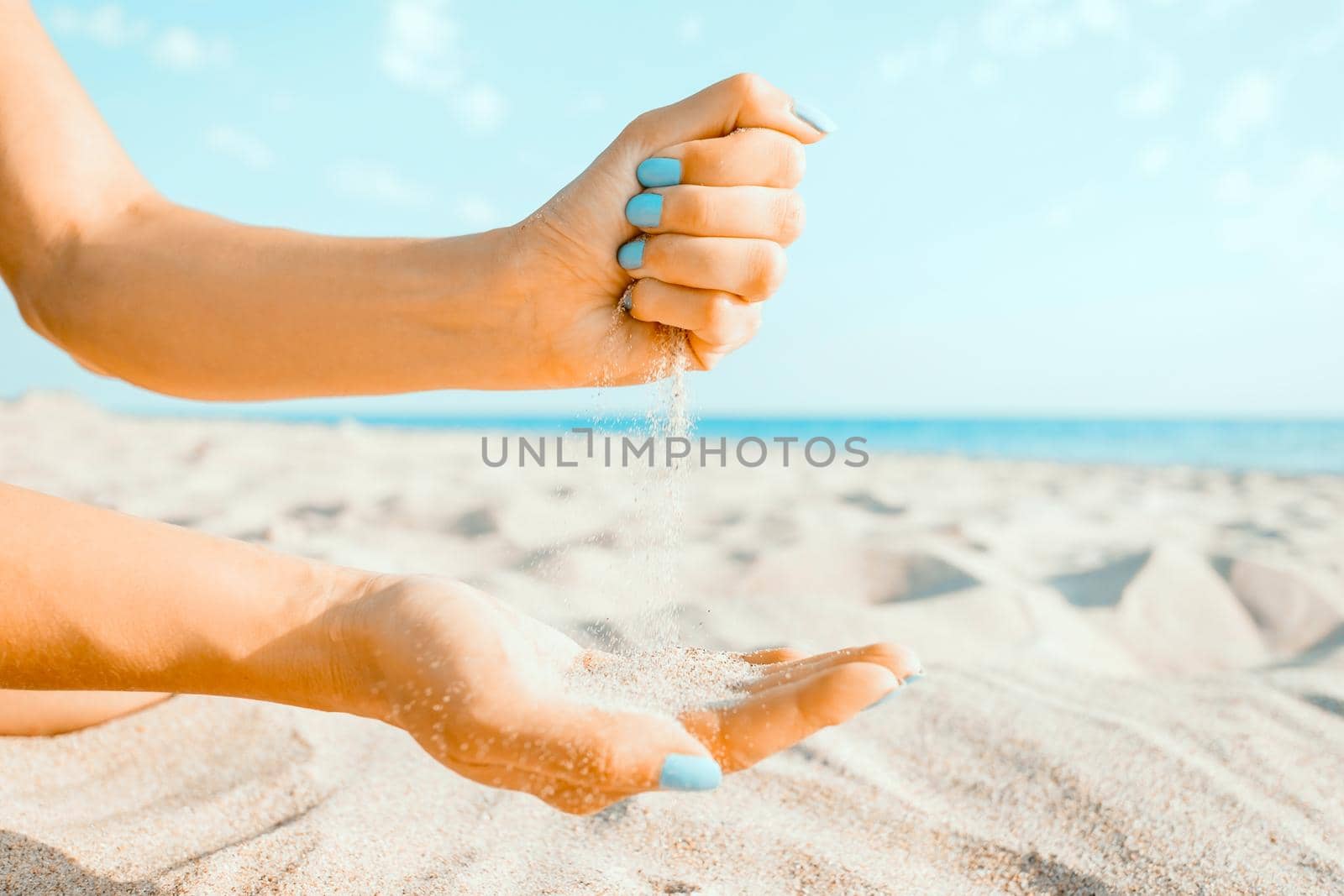 Female hands playing with sand on coastline, beach summer vacations.