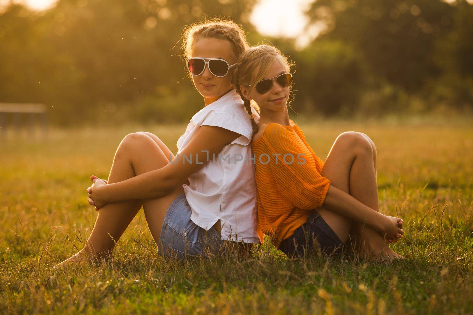 Two teenage girls have fun in the park. Two friends outdoor. Summwer people in glasses