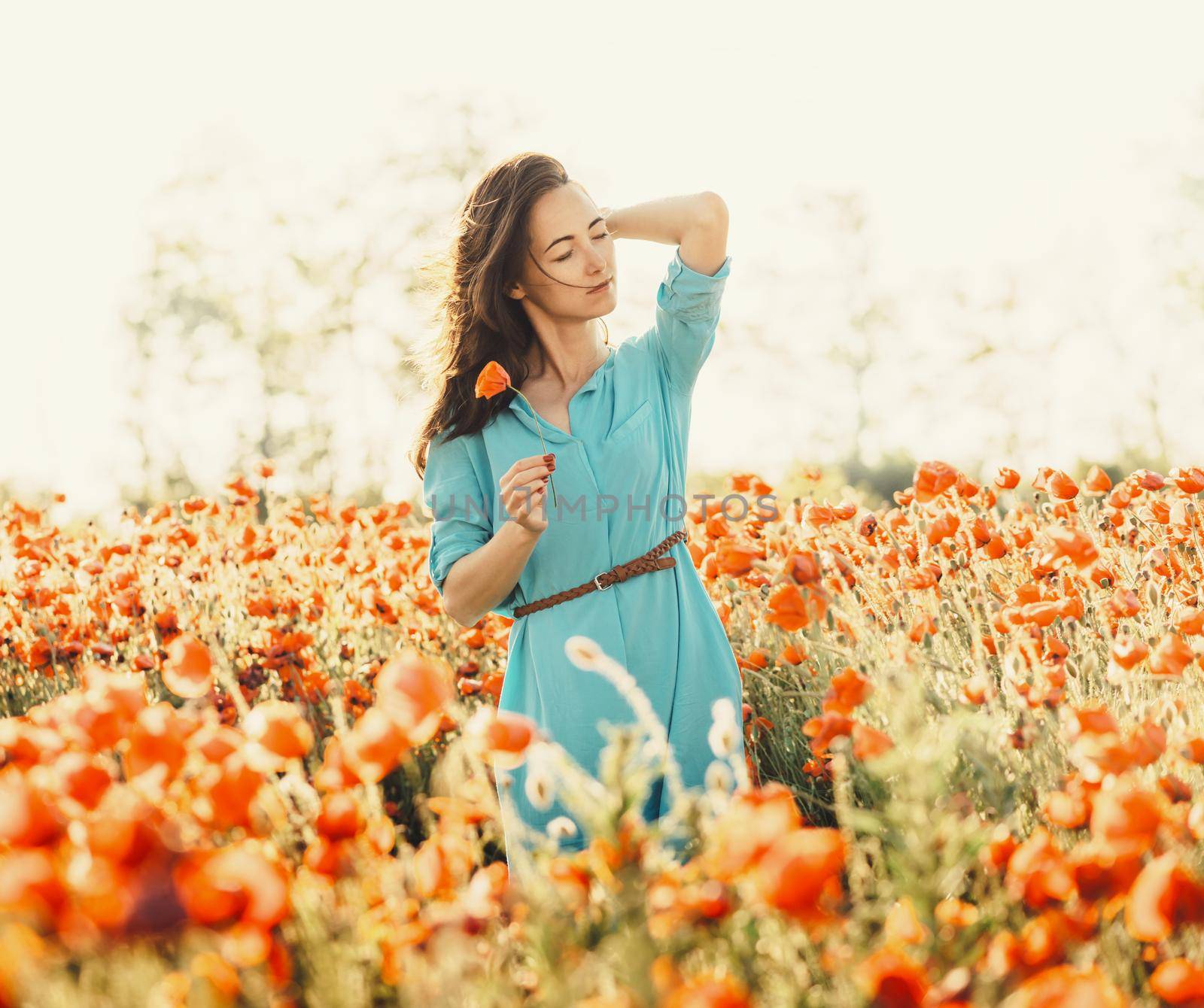 Beautiful woman walking in poppies meadow. by alexAleksei