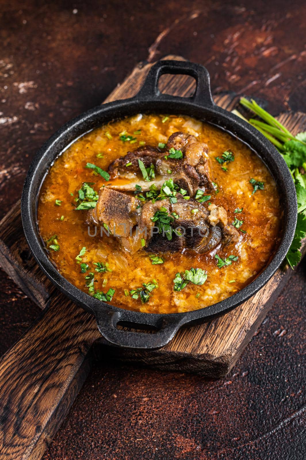 Kharcho soup with lamb meat, rice, tomatoes, carrots, peppers, walnuts and spices. Dark background. Top view.