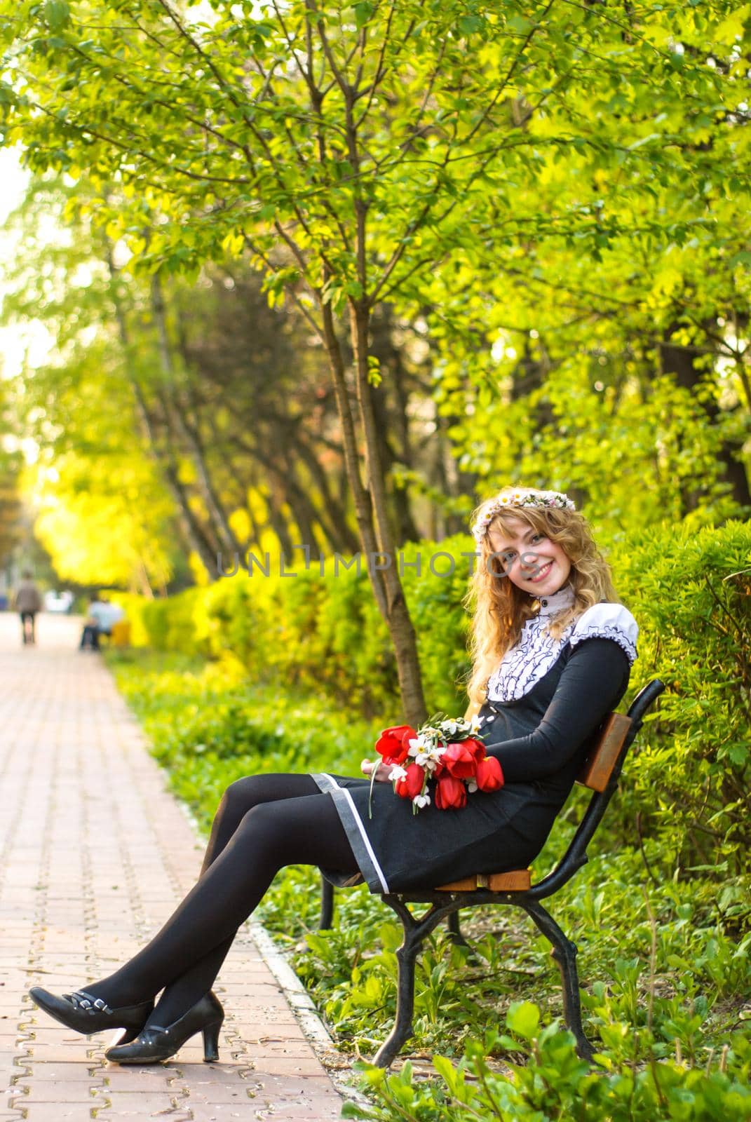 Girl is walking in the park. Cute woman with flowers