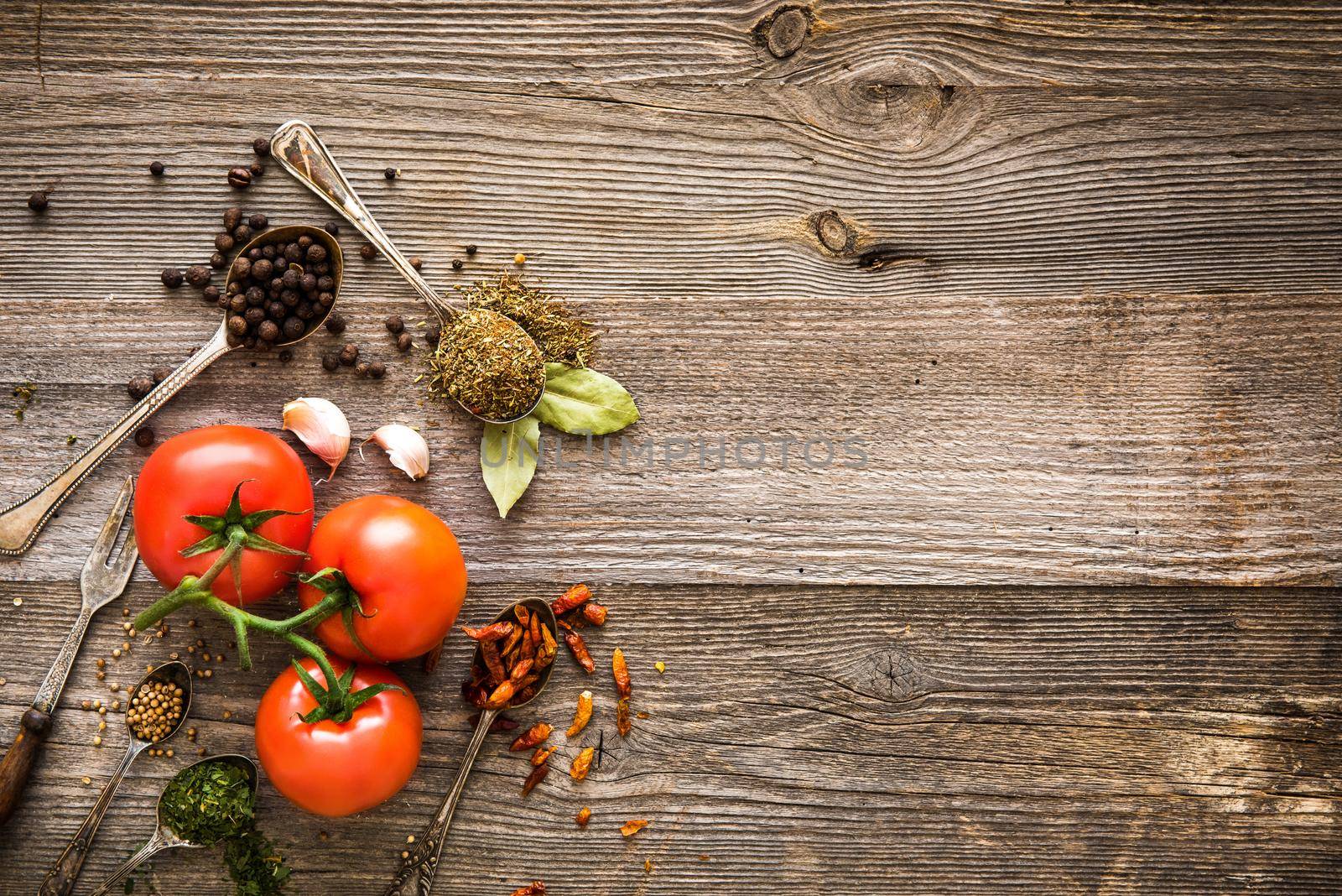 fresh tomatoes and spices on a dark wooden table