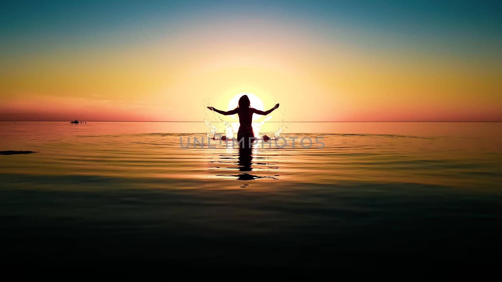 silhouette of a girl with raised hands in the water against the background of the sun disk during a colored sunset by zakob337