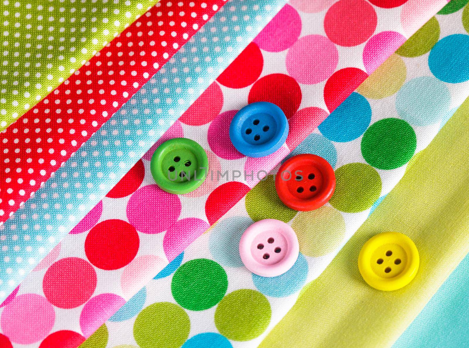 Colorful wooden buttons on the textiles, sew concept