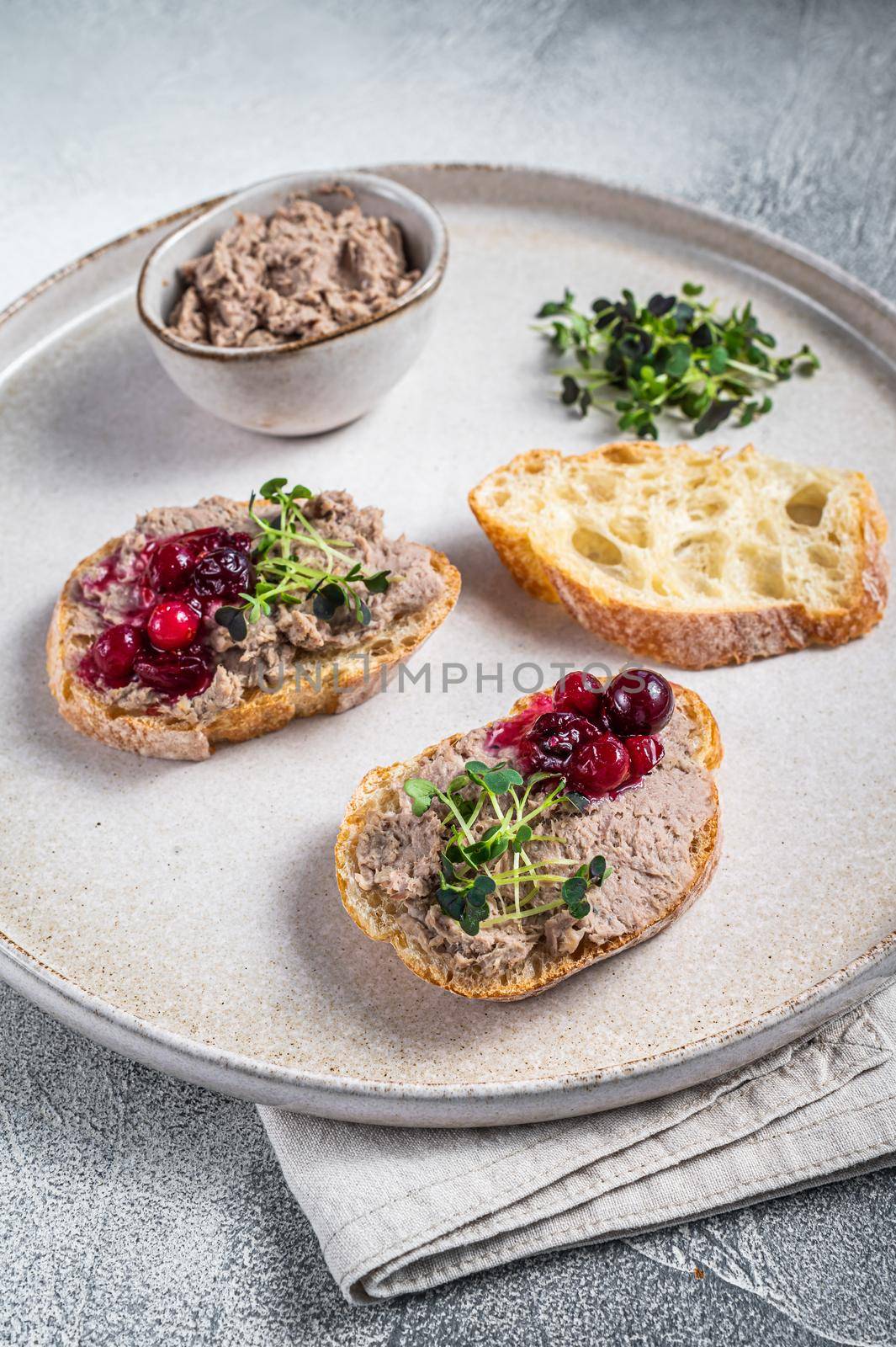 Toasts with chicken rillettes pate on white bread with sprouts. White background. Top View.