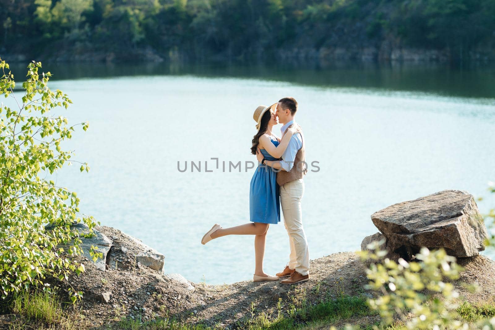 a young couple a guy and a girl are walking near a mountain lake surrounded by granite rocks