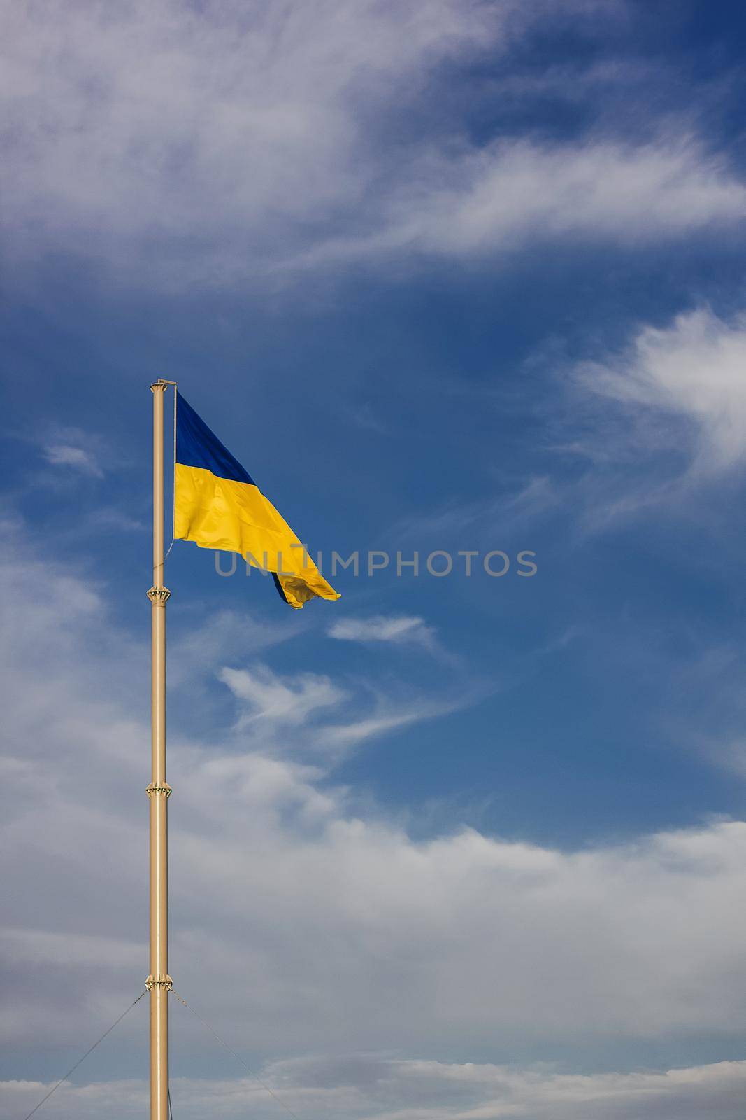 National yellow-blue flag of Ukraine waving on the blue sky background.