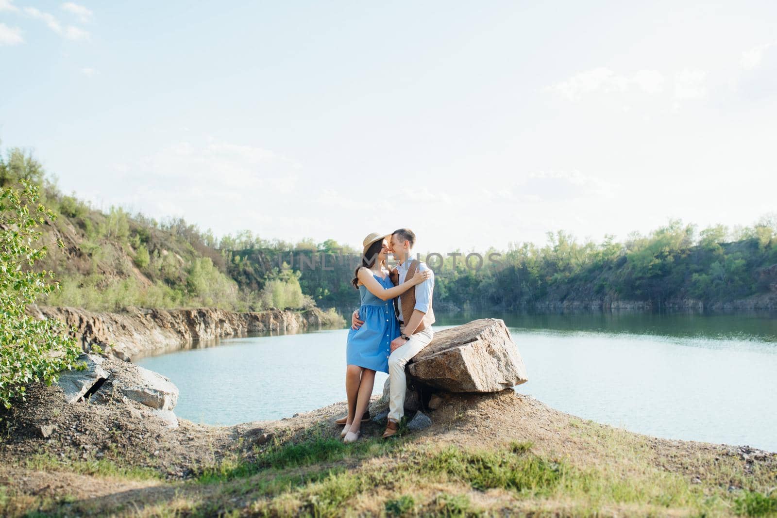 a young couple a guy and a girl are walking near a mountain lake surrounded by granite rocks