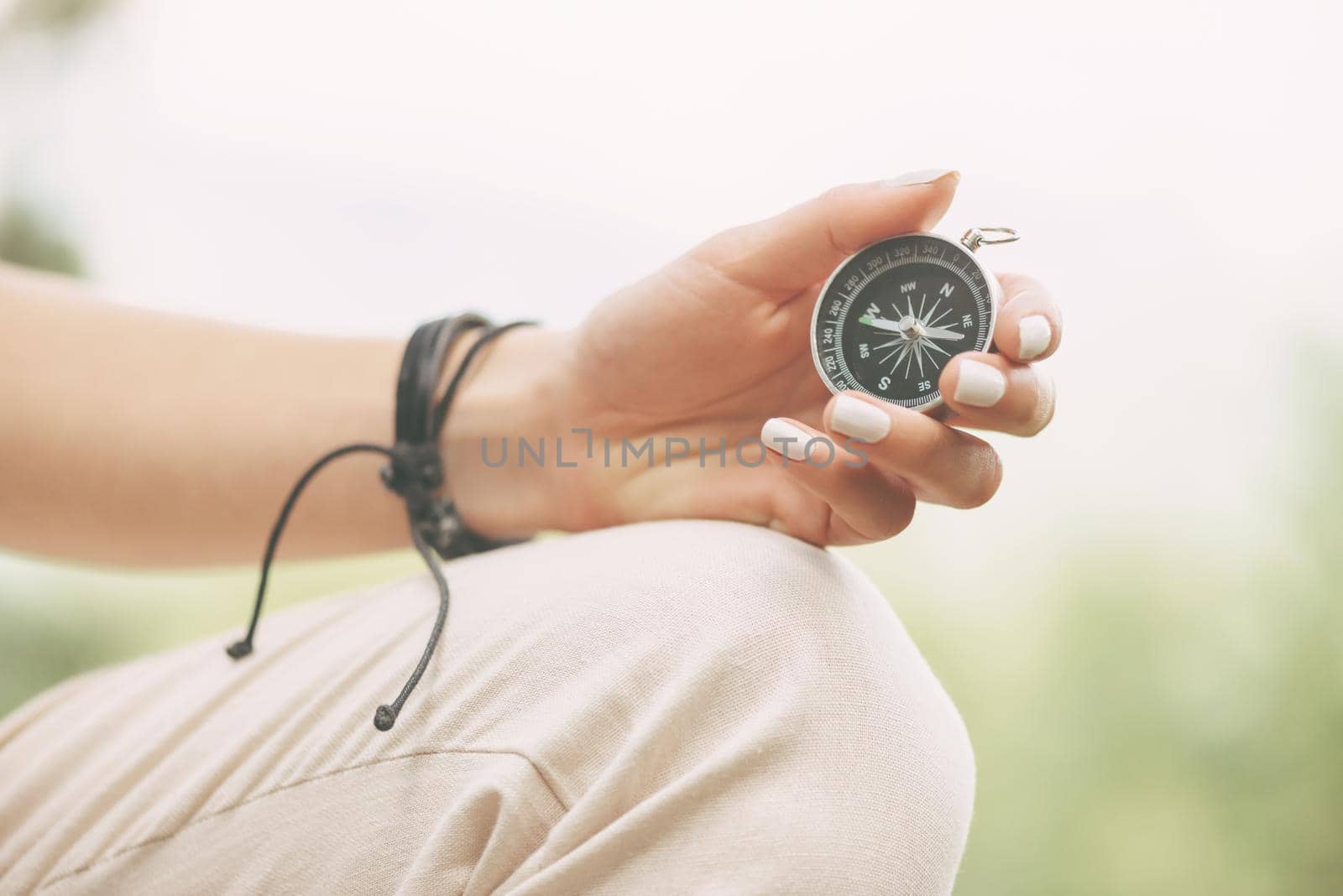 Female hand with magnetic compass outdoor.