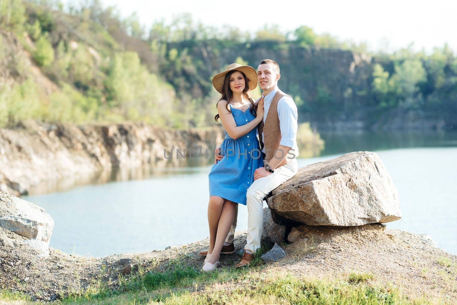 a young couple a guy and a girl are walking near a mountain lake surrounded by Andreua