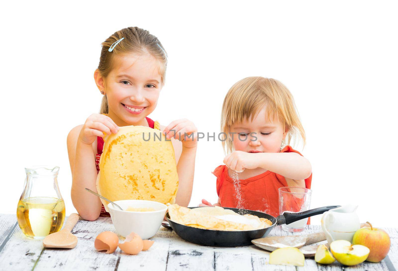 funny sisters cooking pancakes on kitchen, white background