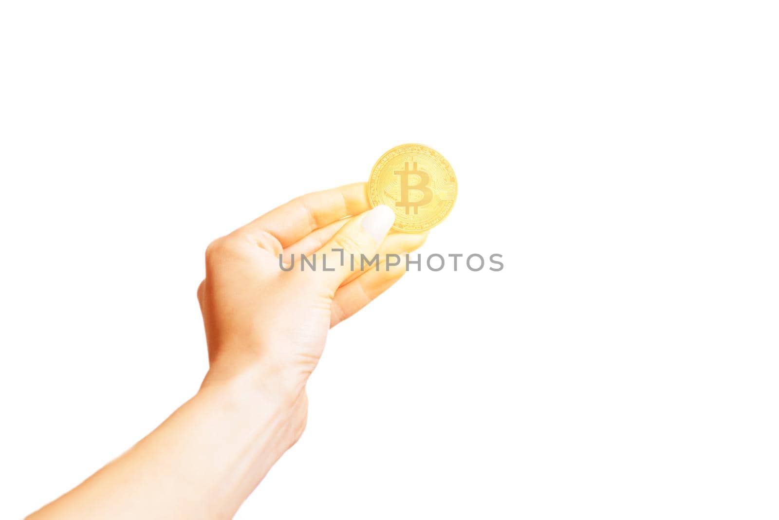 Female hand holding glowing gold bitcoin isolated on a white background.