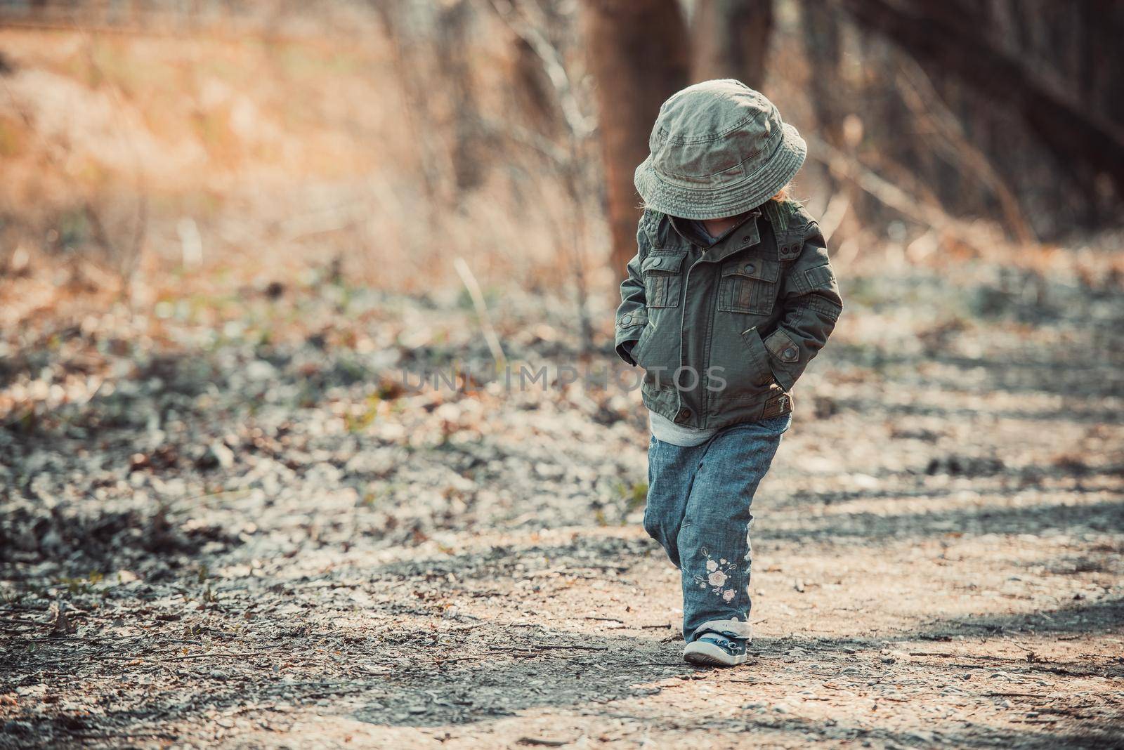 Funny little child walking in the woods, photo in vintage style