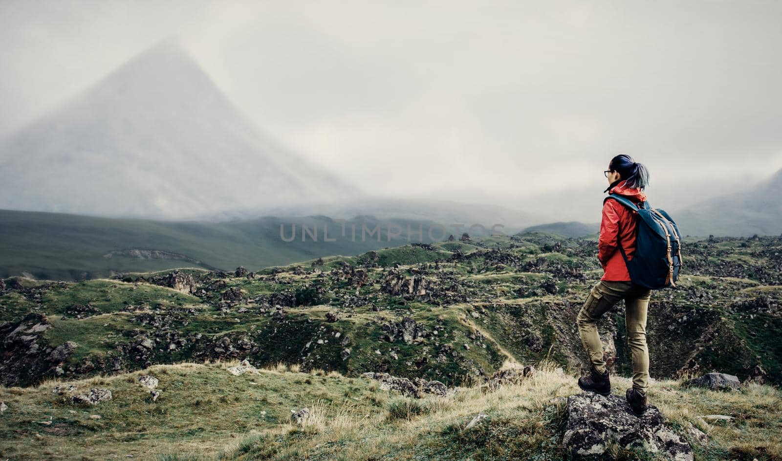 Backpacker woman walking in mountain valley. by alexAleksei