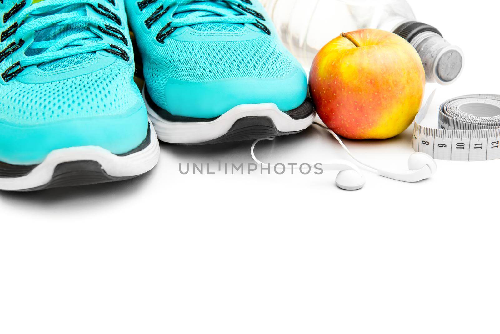 sport background: blue running shoes and apple with objects isolated on white background