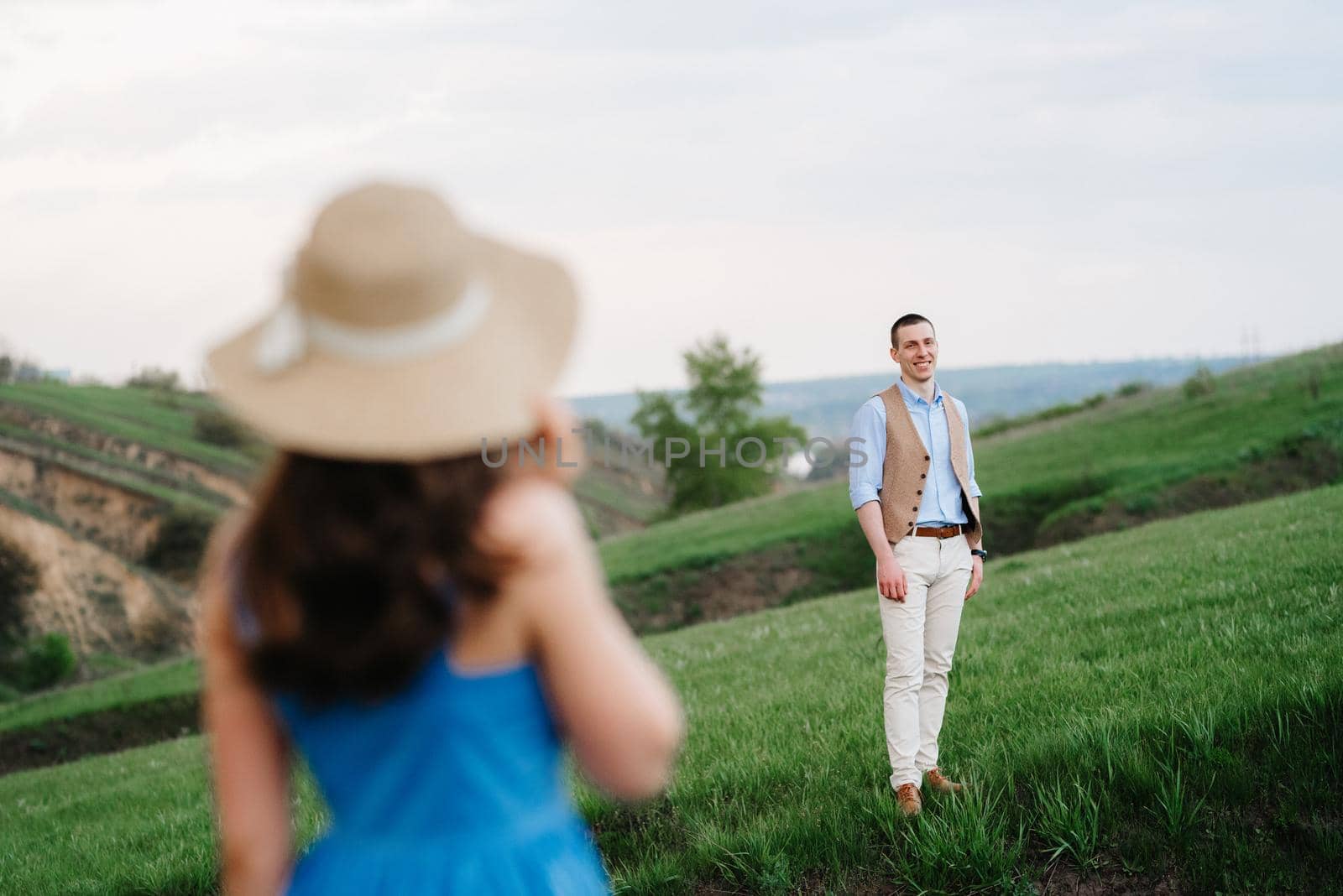 young couple a guy and a girl are walking in the mountain hills by Andreua