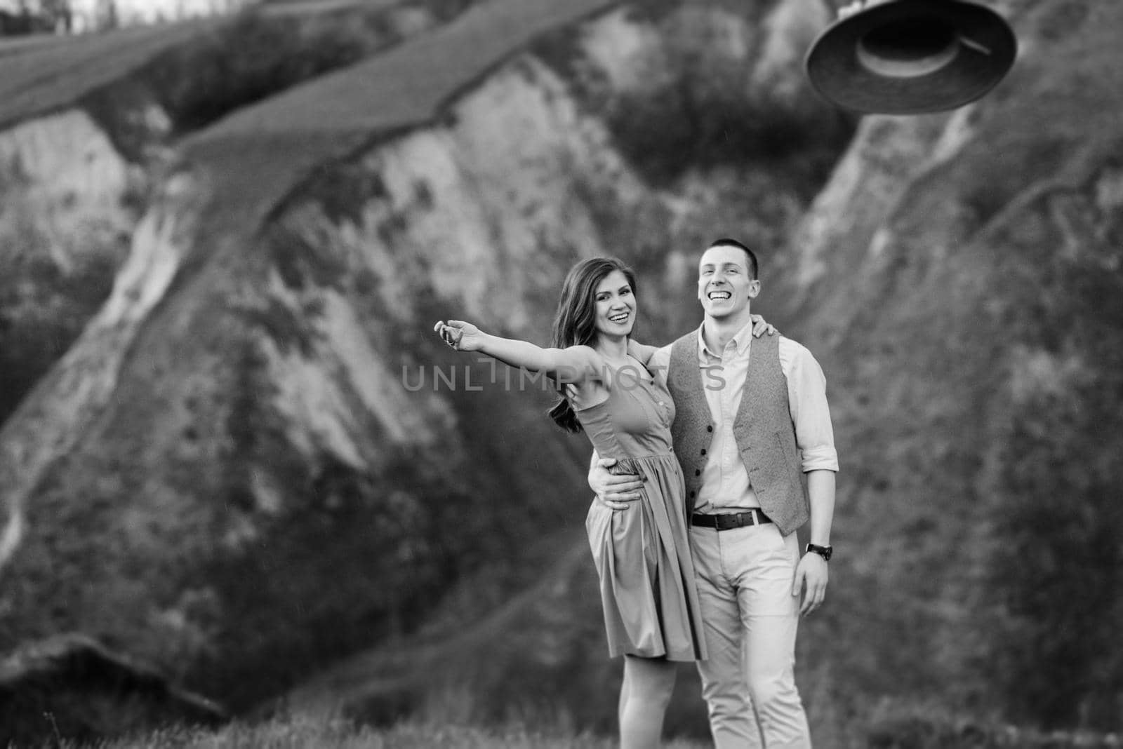 young couple a guy and a girl are walking in the green mountain hills