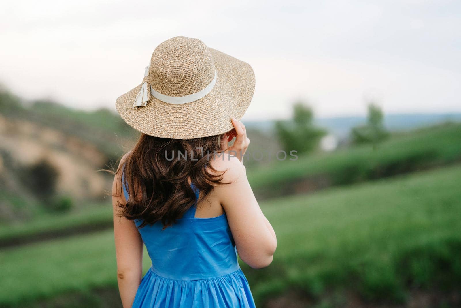 young girl in a straw hat with large brim on mountain slopes by Andreua