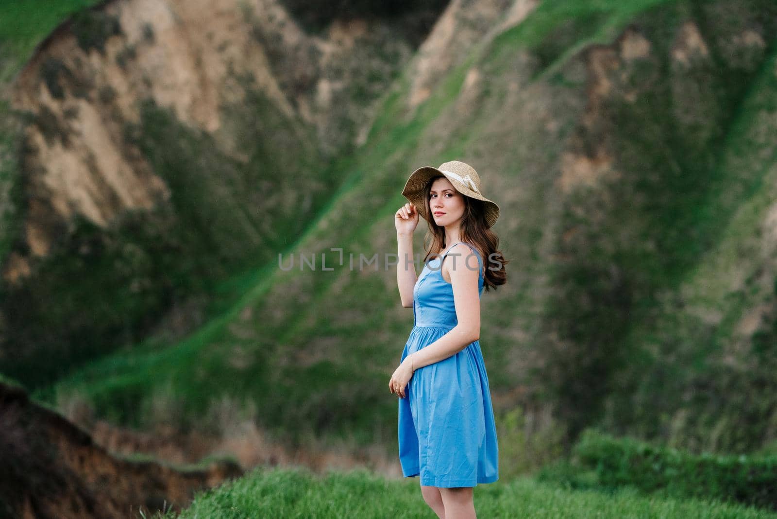 young girl in a straw hat with large brim on mountain slopes by Andreua