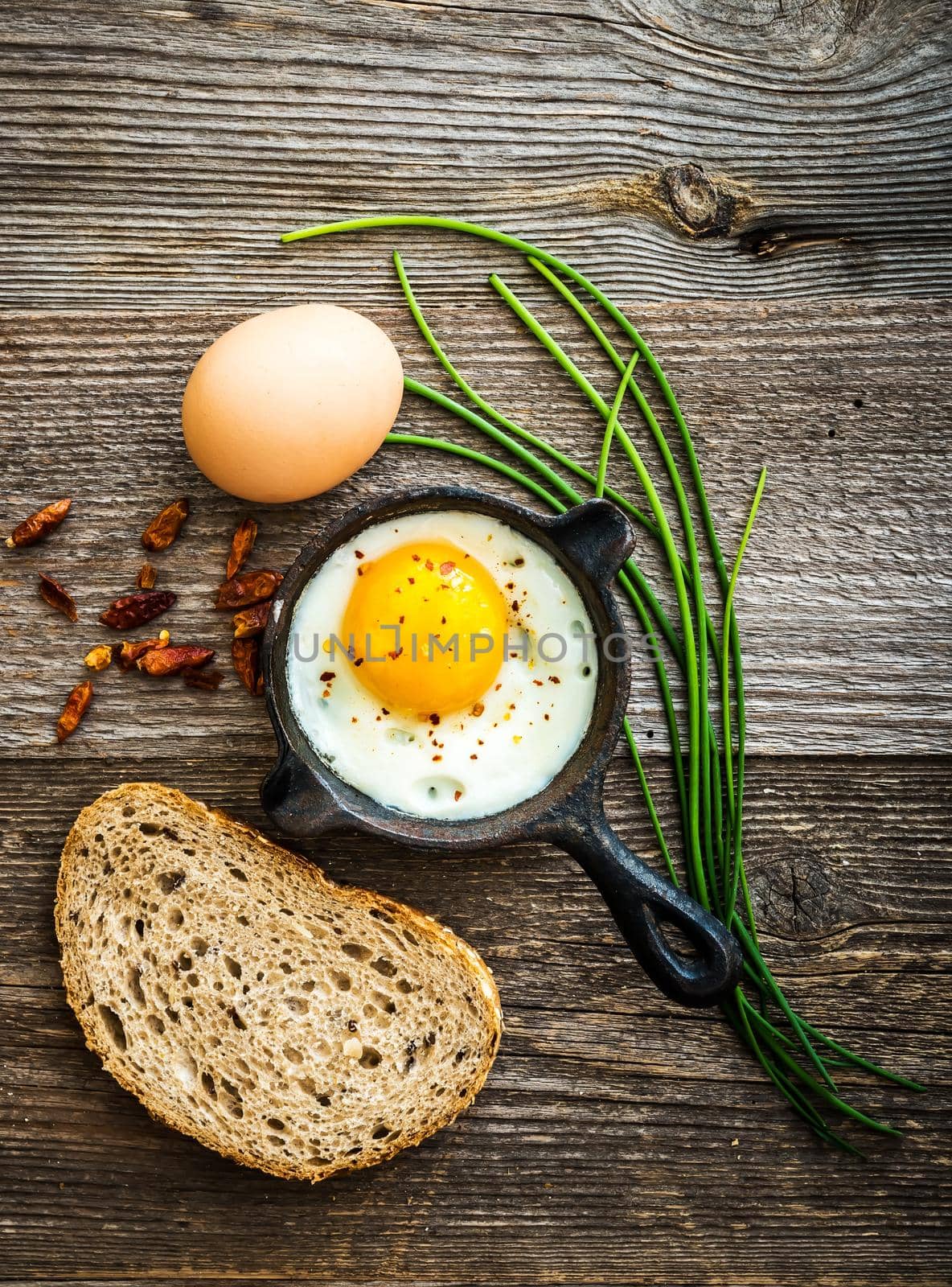breakfast with eggs and grey bread on wooden background