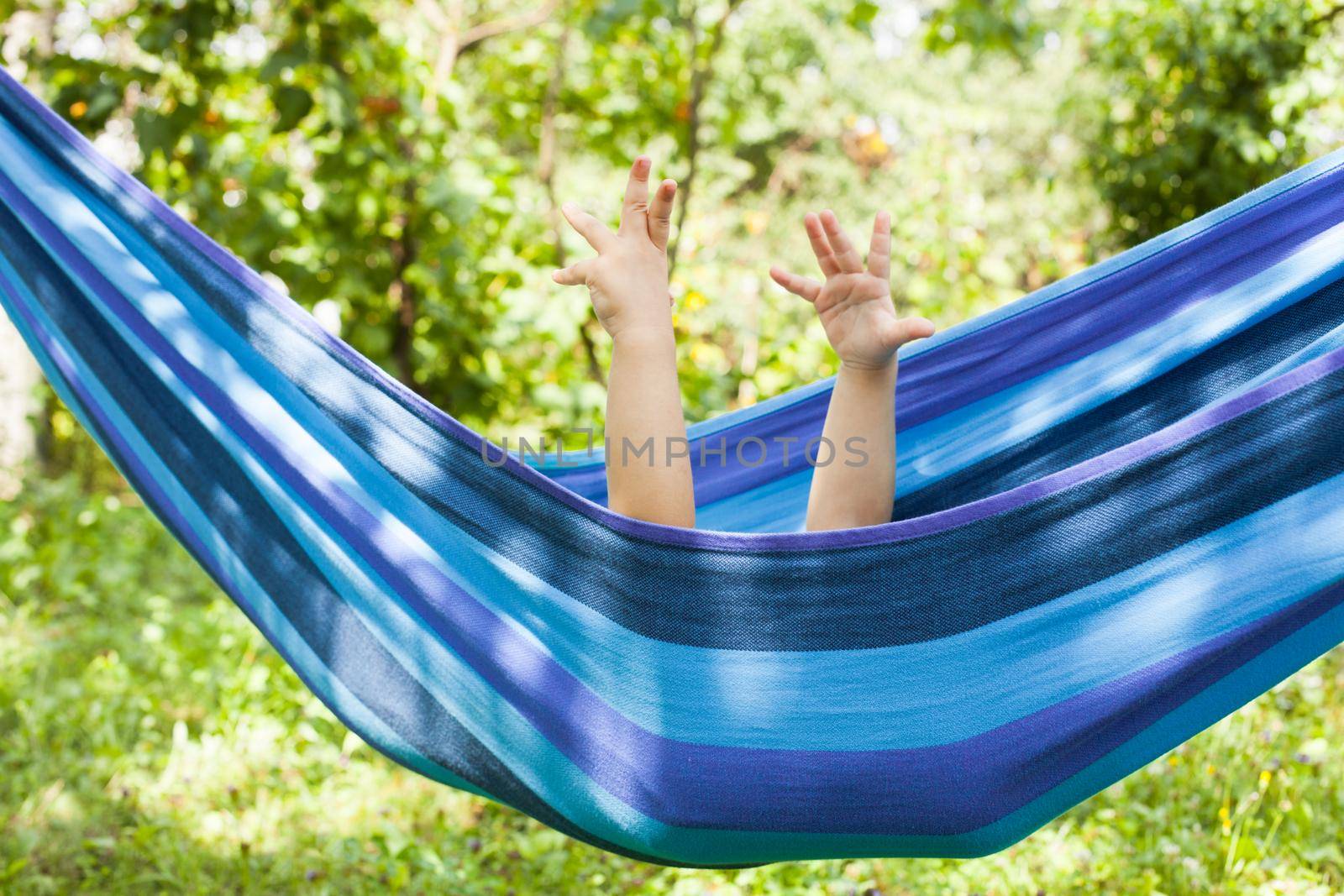 Little girl in a hammock with hands up