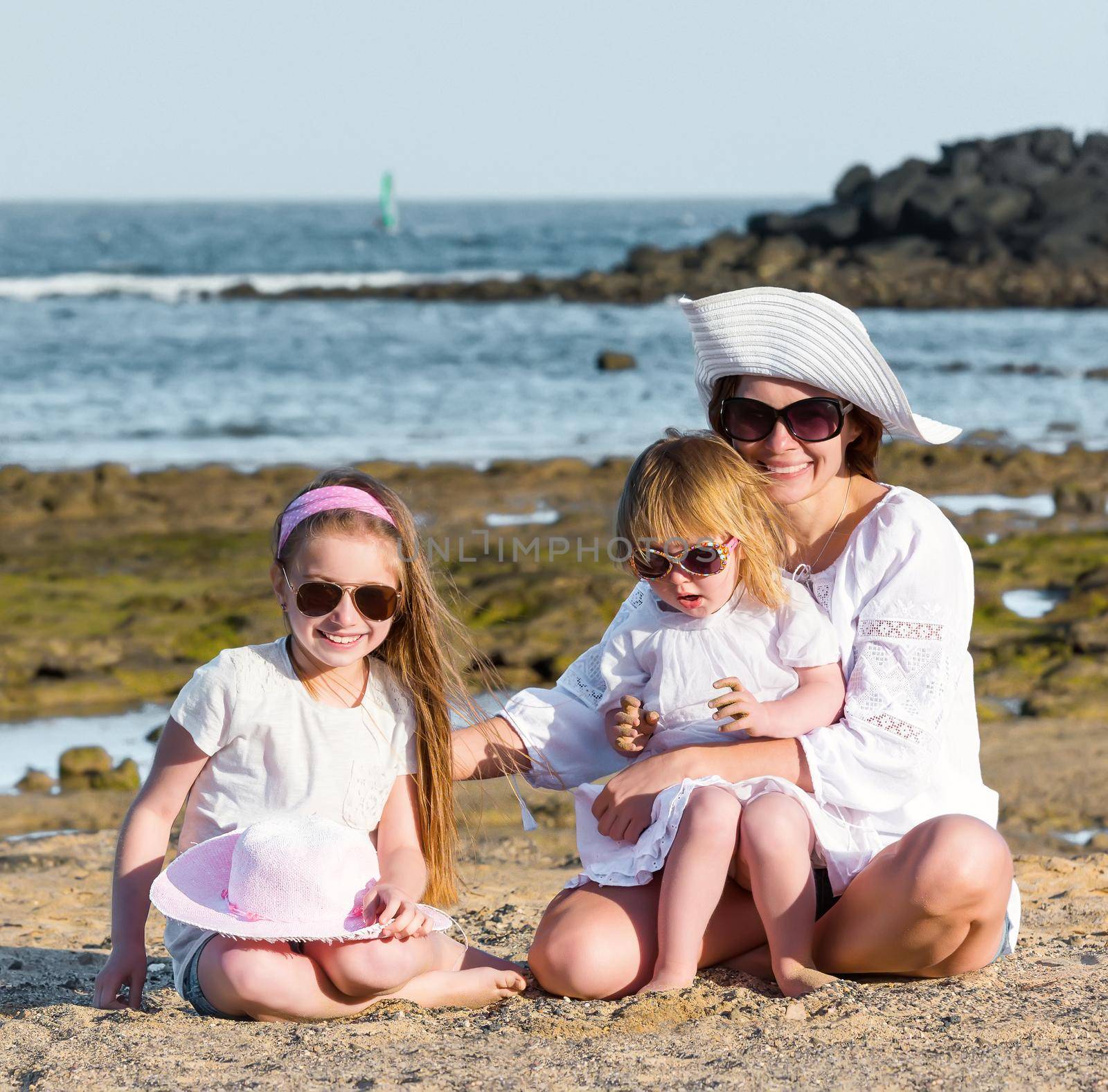 mother with two daughters on the beach