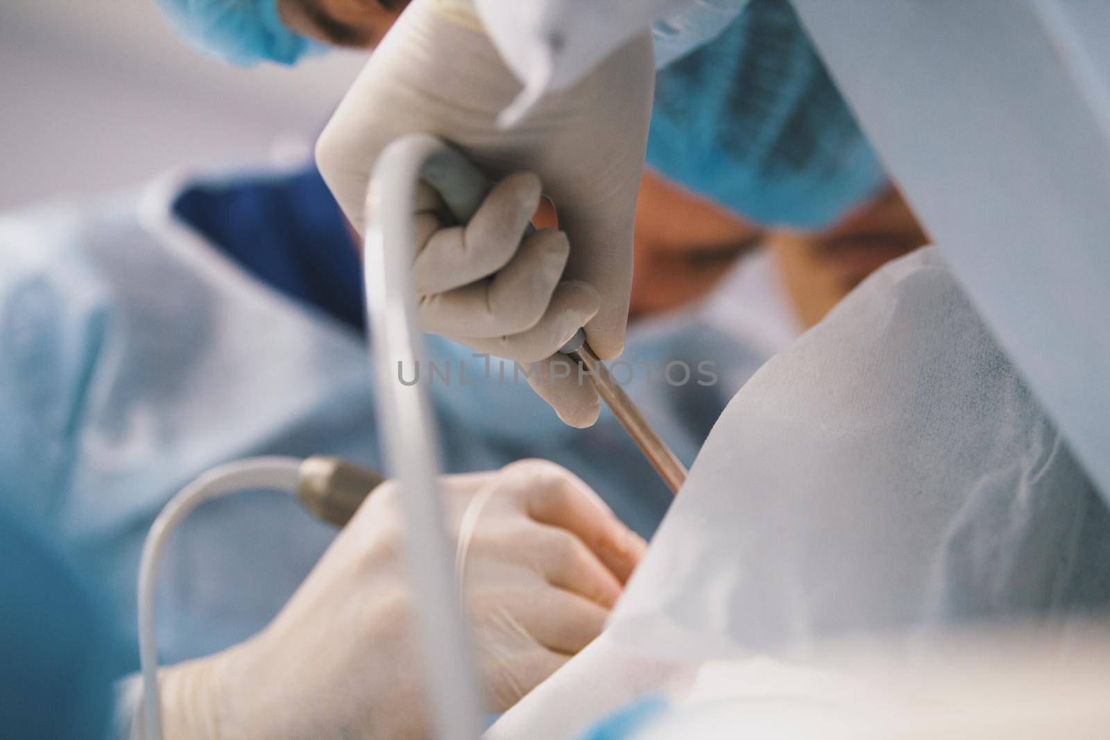 Surgeons in surgery room makes medical operation for patient, close up