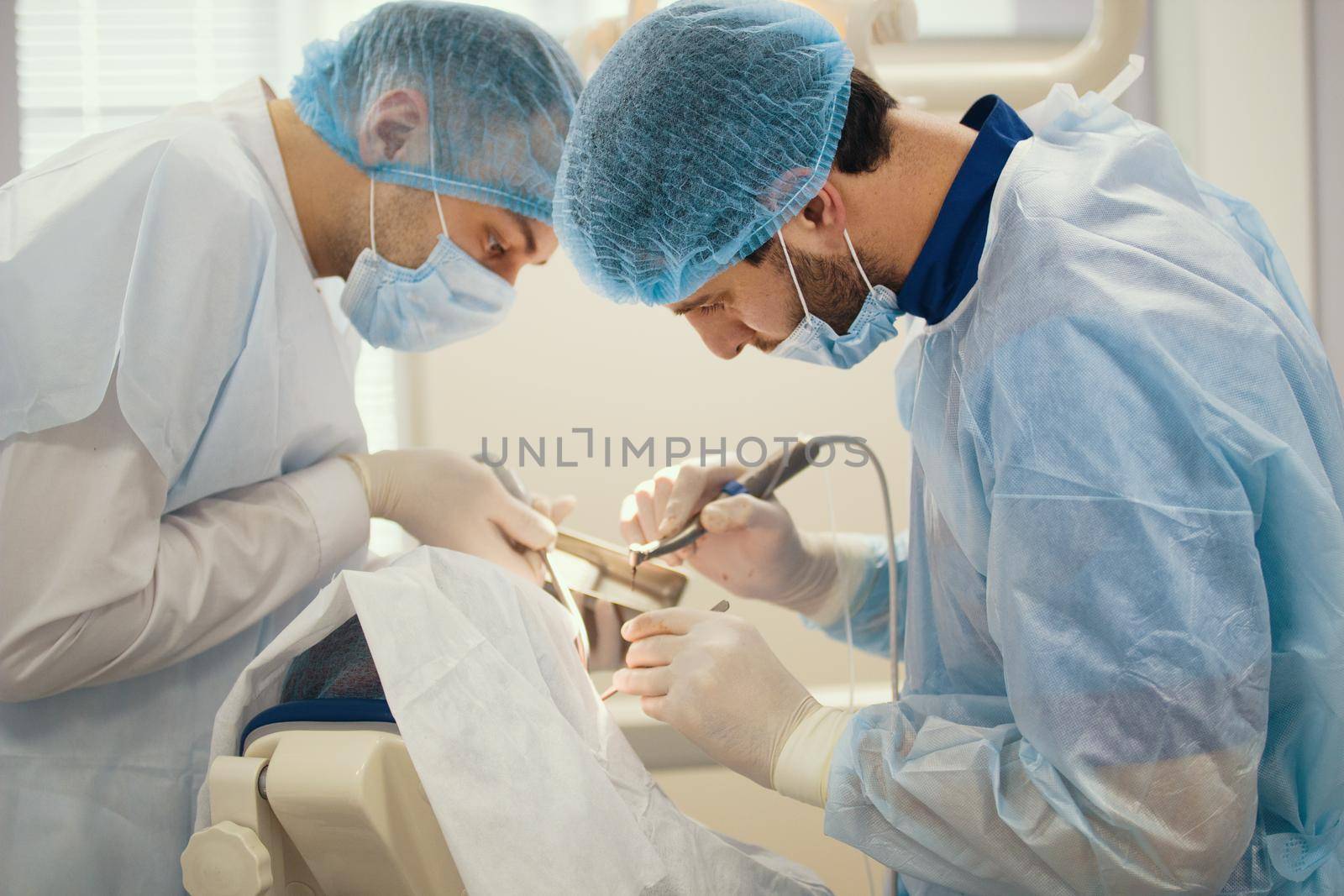 Doctor dentist and assistant during stomatology operation, close up