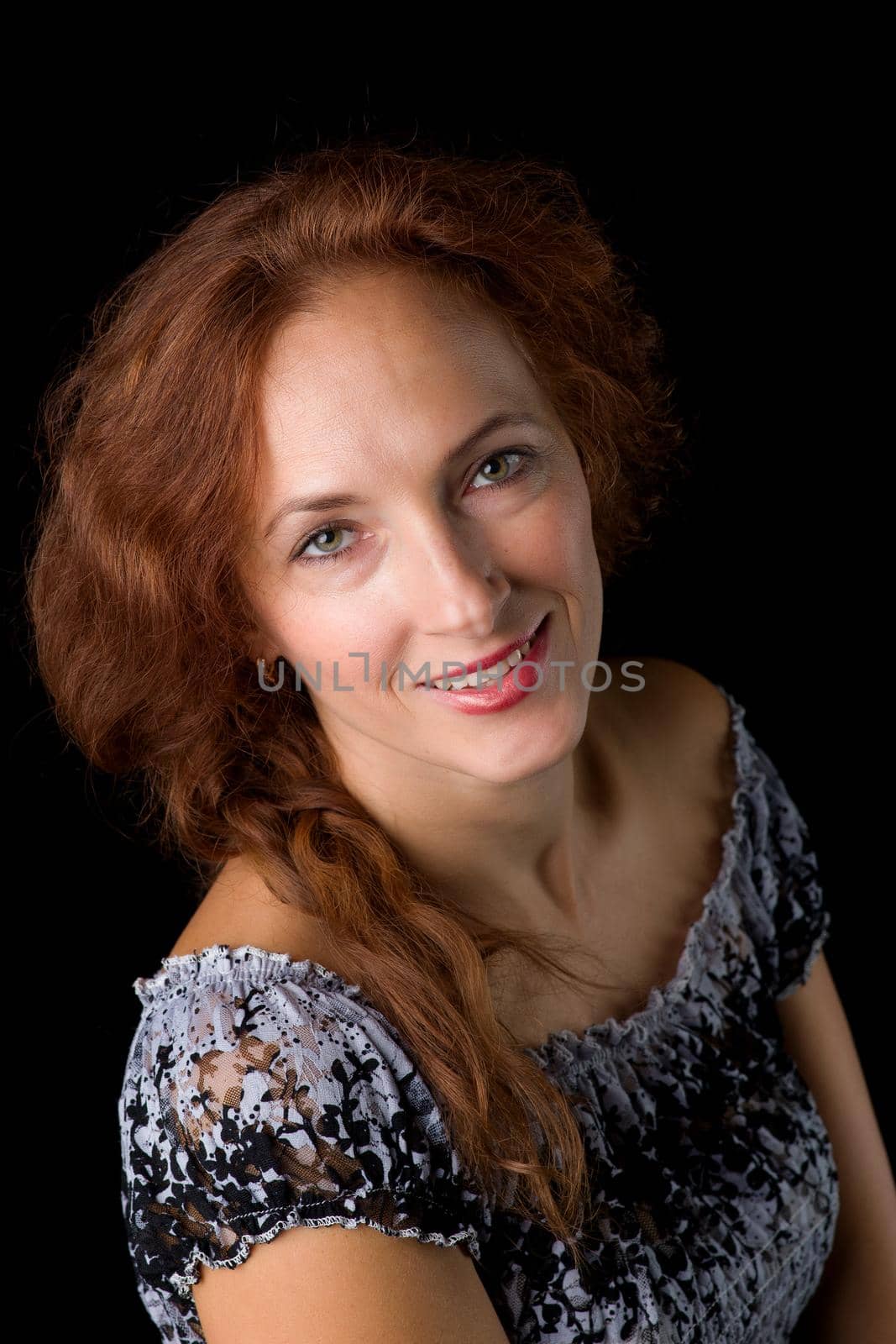 Close up portrait of beautiful woman. Happy young woman in sundress posing against black background. Portrait of smiling girl looking at camera