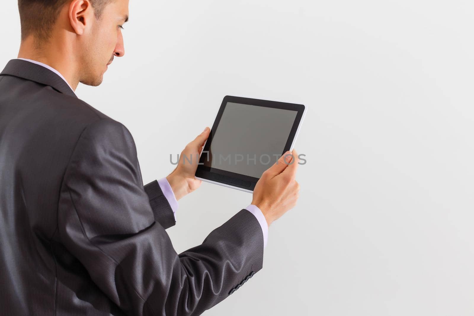The businessman holding tablet against white background