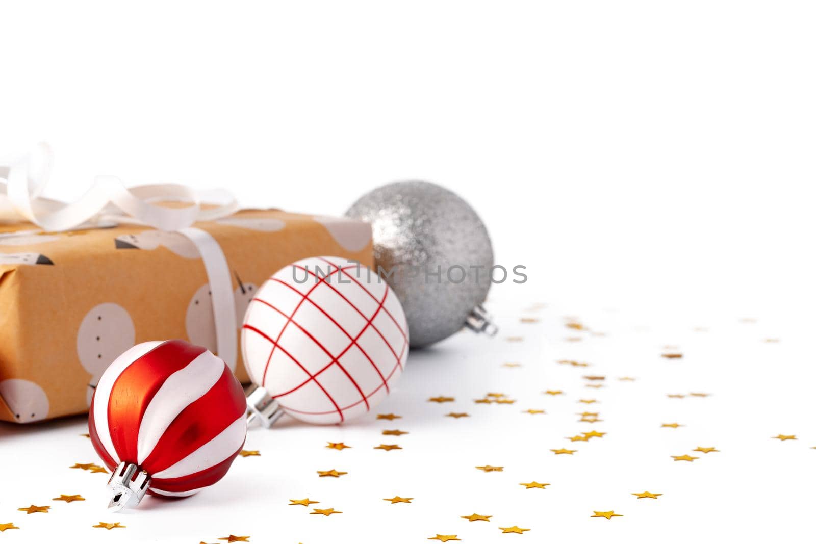 Christmas baubles and festive gift box isolated on white background, close up