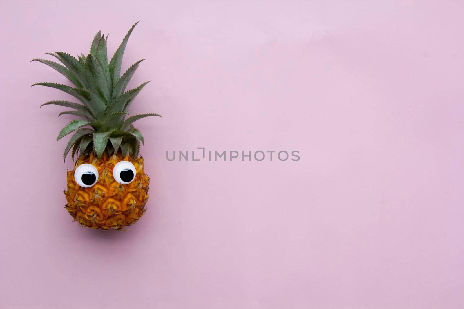 View at exotic tasty fruit pineapple at pink background by uveita