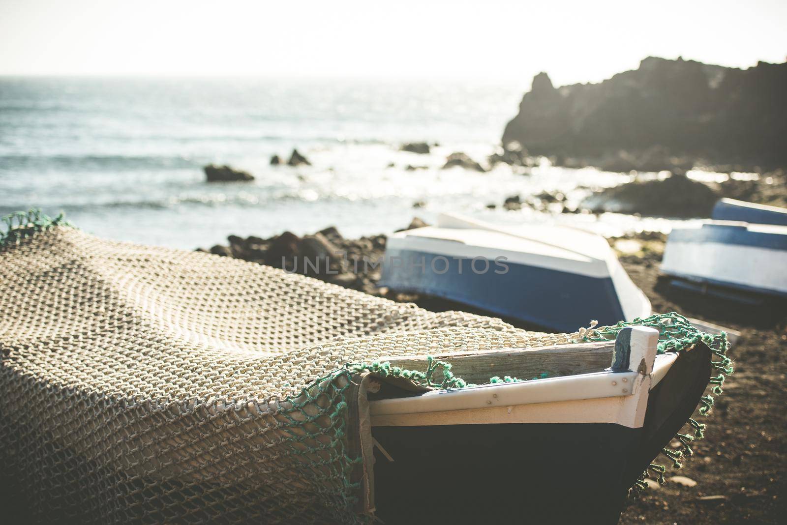 boat on a sandy shore on rocky coastline background