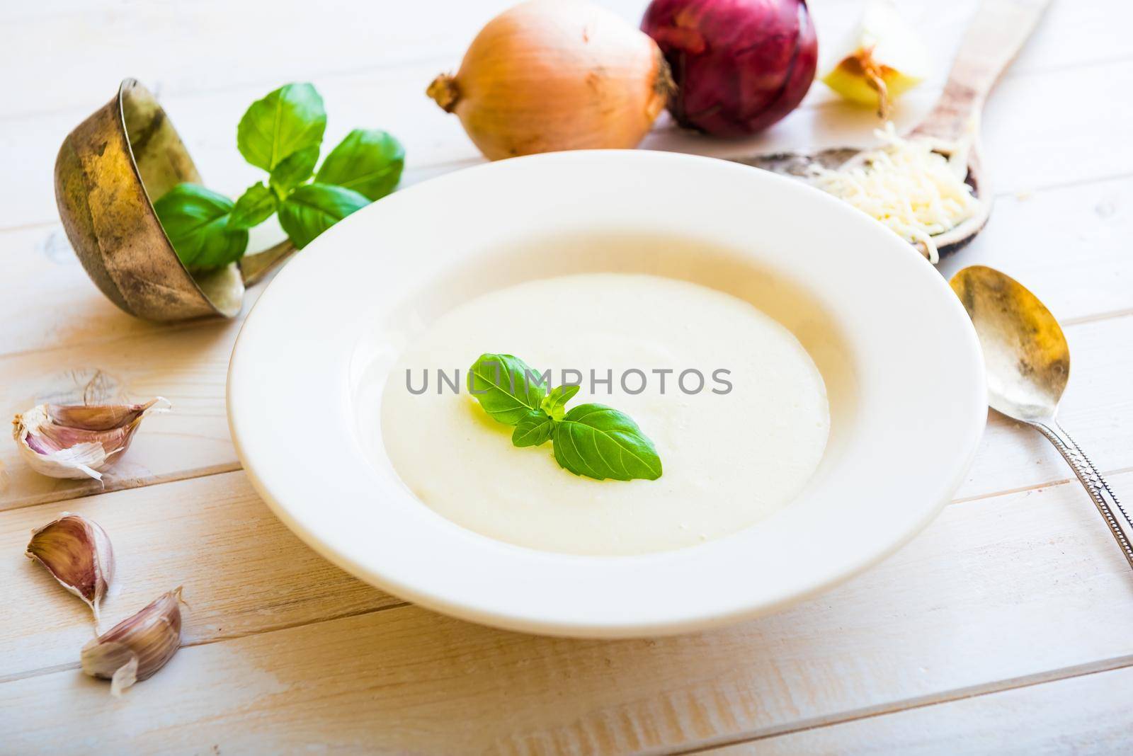 onion soup puree in a white plate cheese on the table