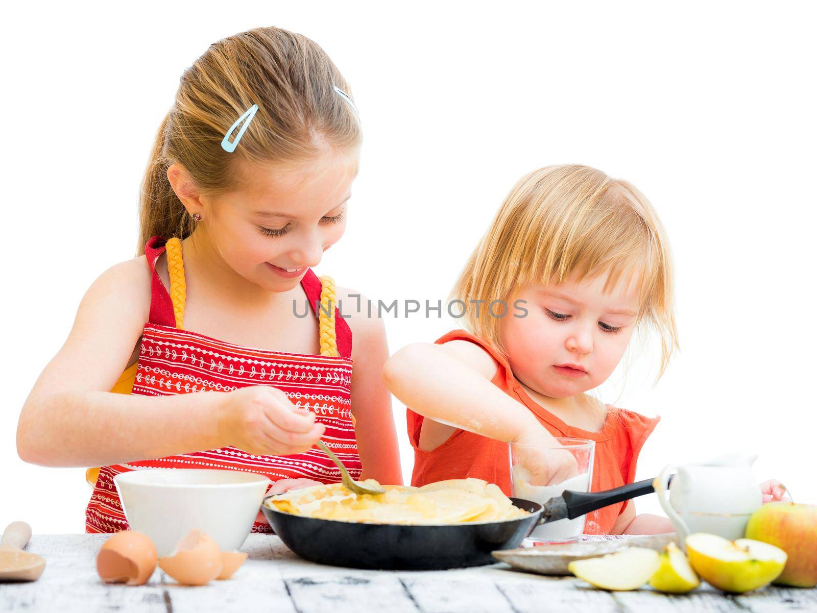 cute sisters cooking pancakes on kitchen isolated on a white background