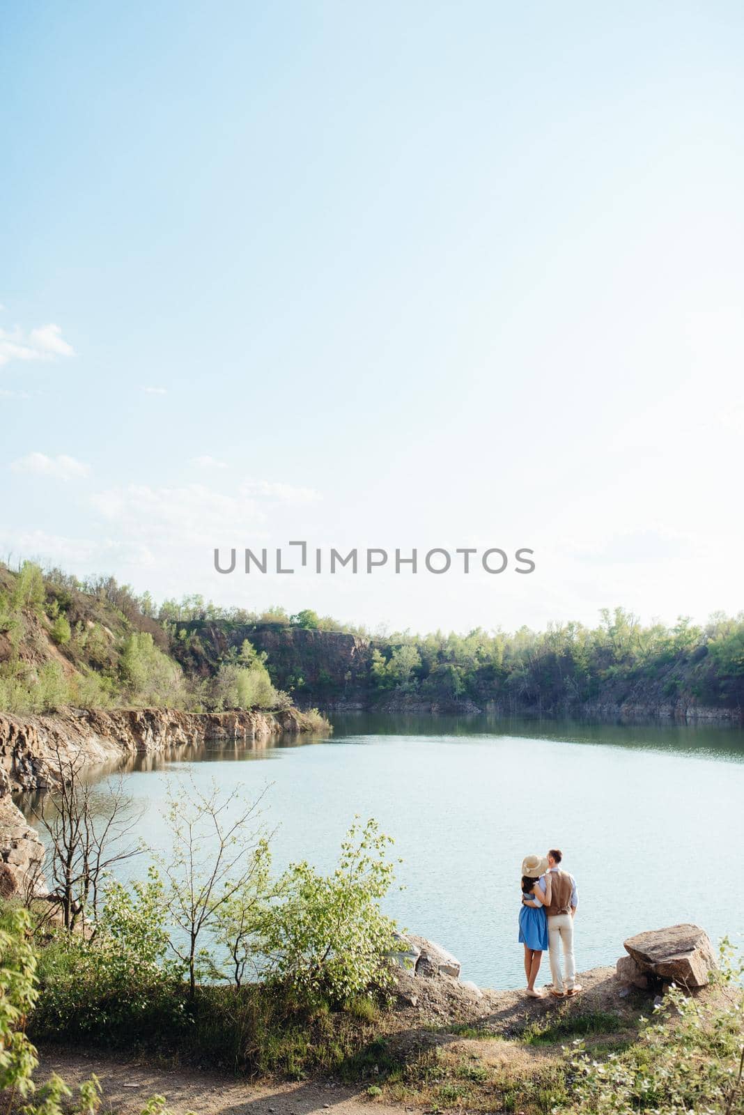 a young couple a guy and a girl are walking near a mountain lake surrounded by granite rocks