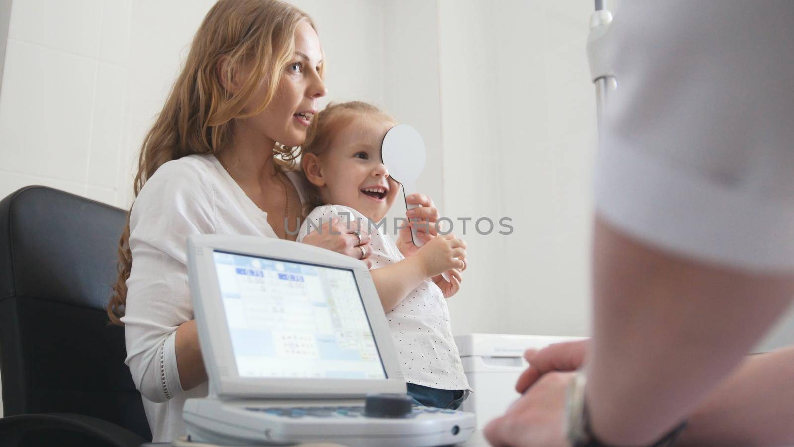 Kids ophthalmology - optometrist Checks Eye of little girl, close up