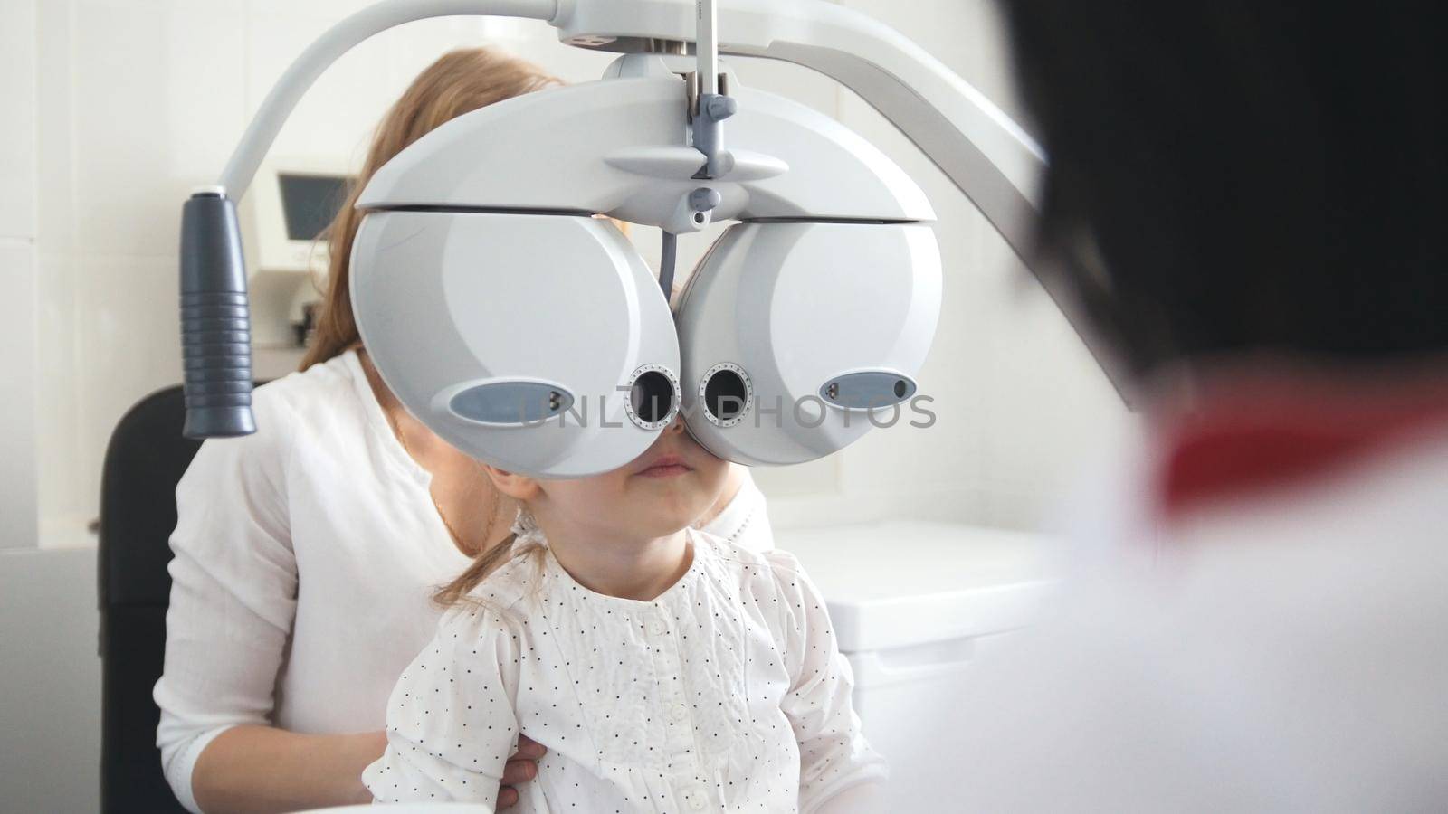 Children ophthalmology - optometrist Checks Eye of little girl by Studia72