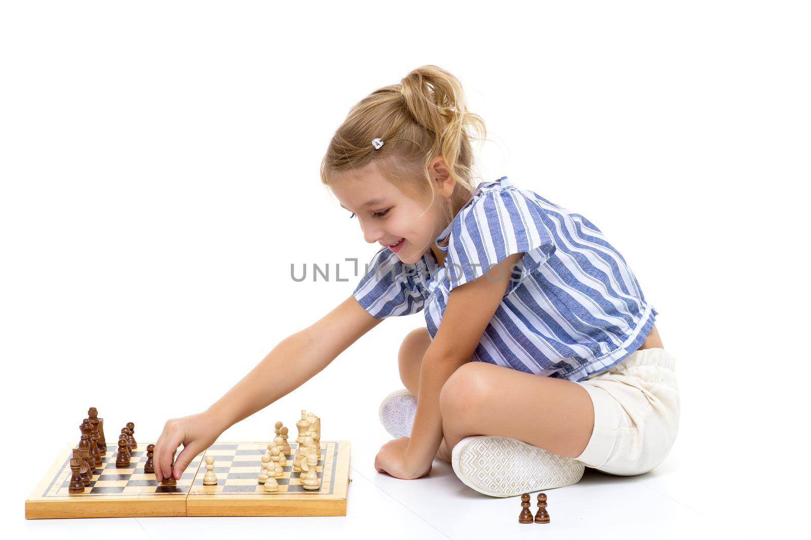 Little girl playing chess.On white background. by kolesnikov_studio