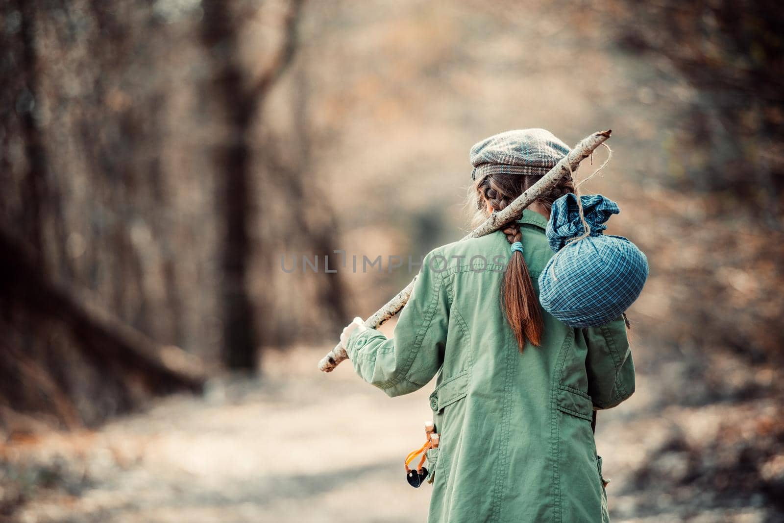 little girl goes on a footpath in the forest with stuff, photo in retro style