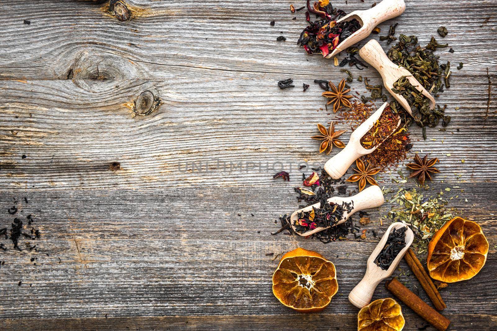 odorous dry teas in scoops on wooden background