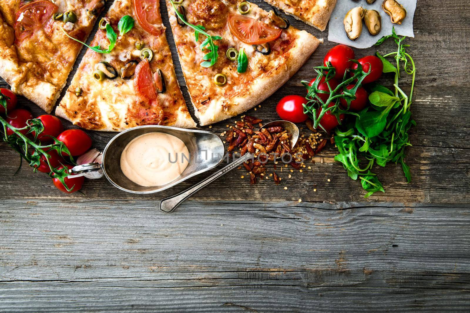 Tasty seafood pizza with cherries on a wooden table