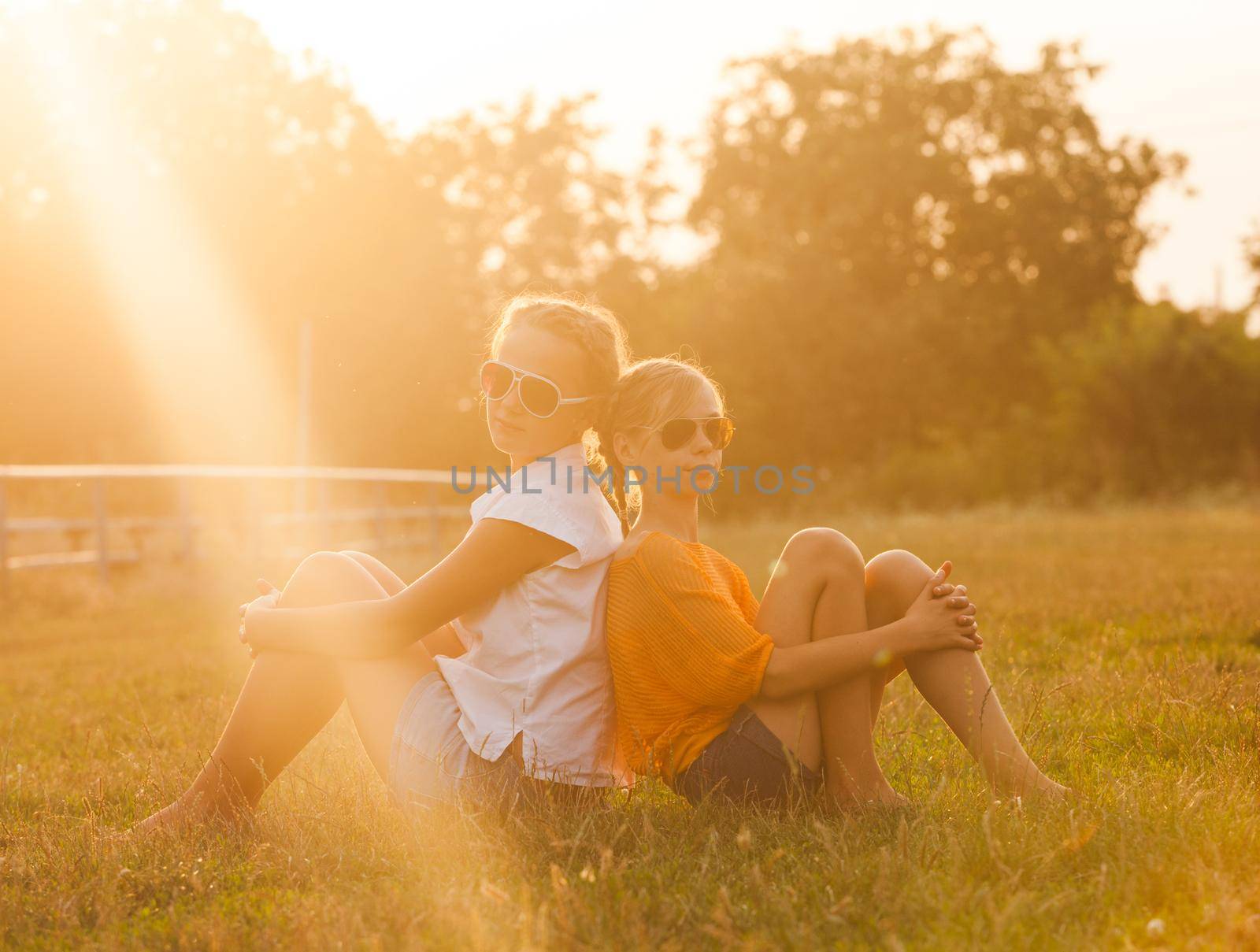 Two teenage girls have fun in the park. Two friends outdoor. Summwer people in glasses