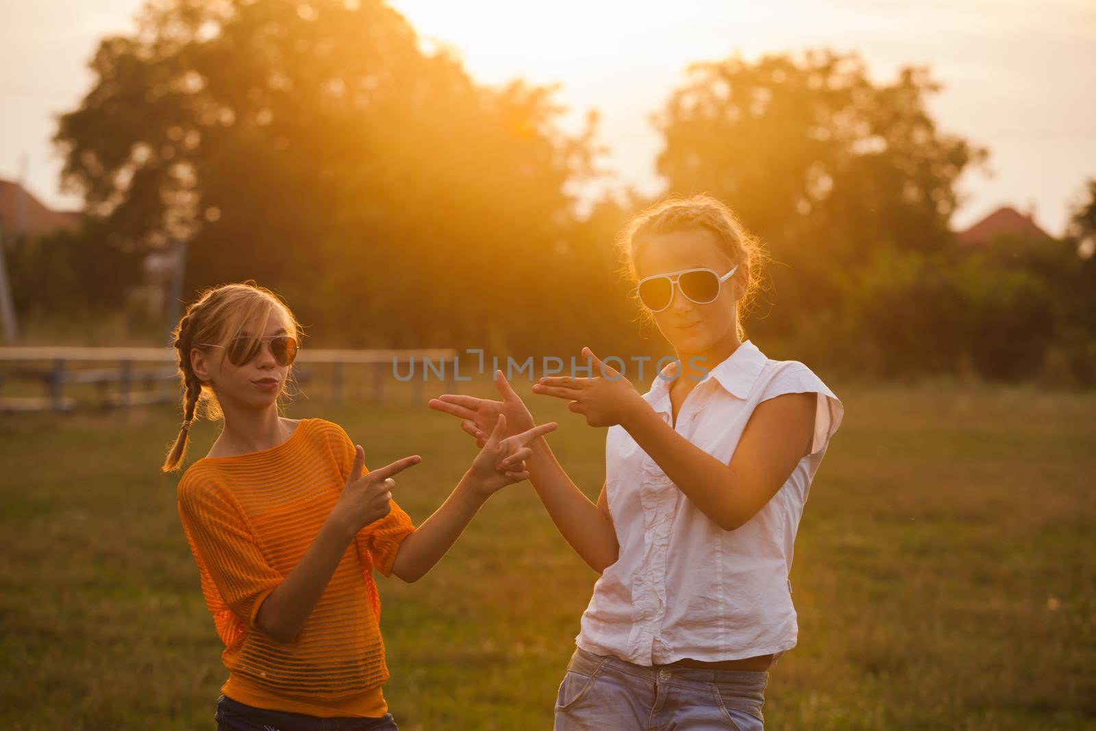 Two teenage girls have fun in the park. Two friends outdoor. Summer people in glasses