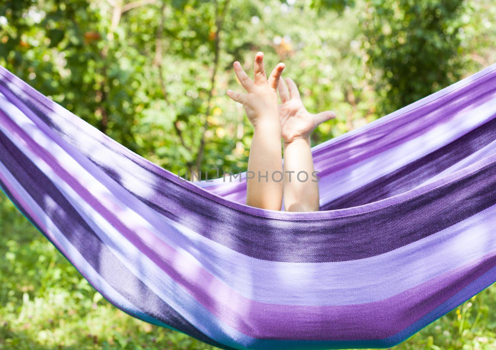 Little girl in a hammock with hands up