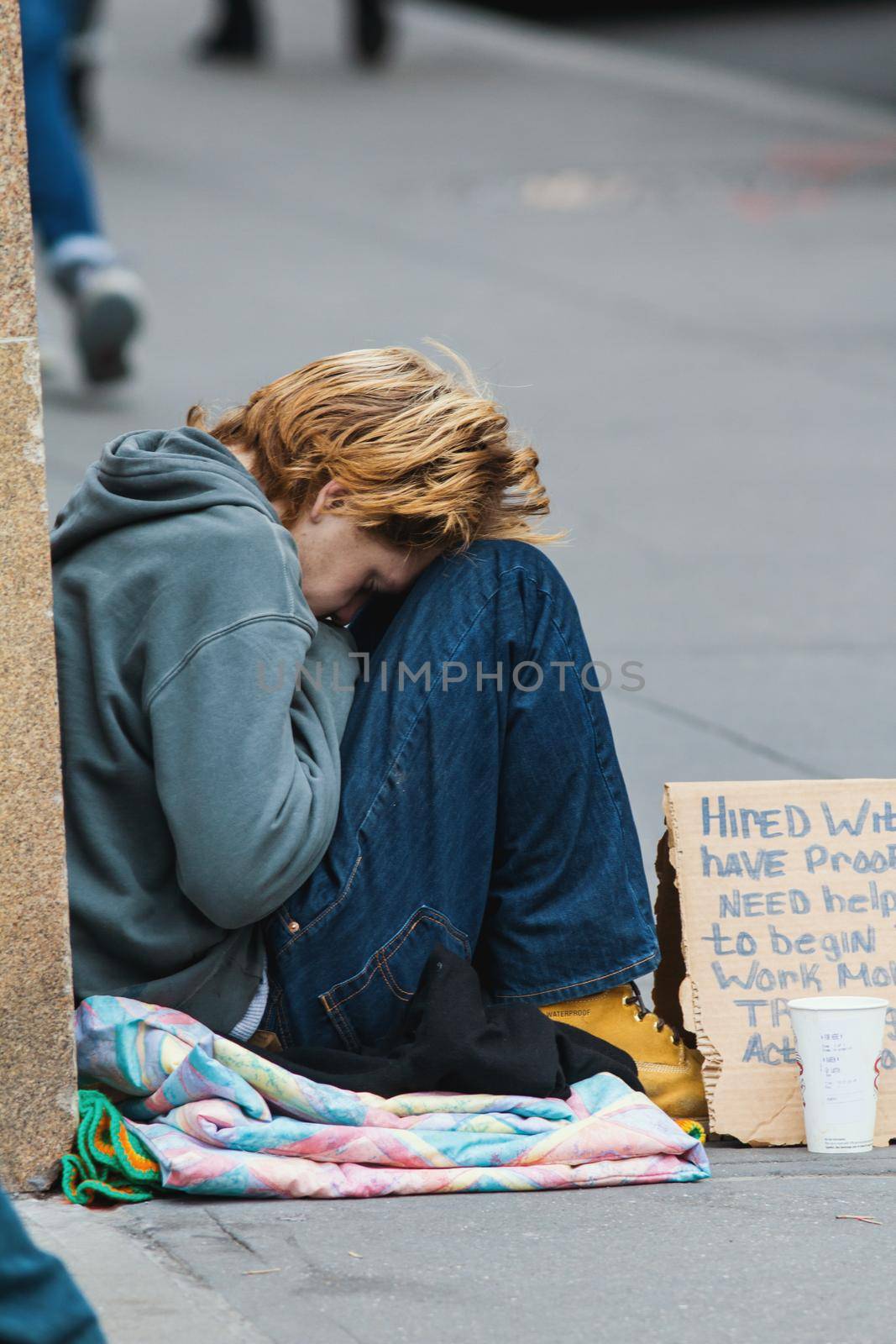 New York, USA - December 2017 - depressive homeless female on the street of new york, telephoto shot