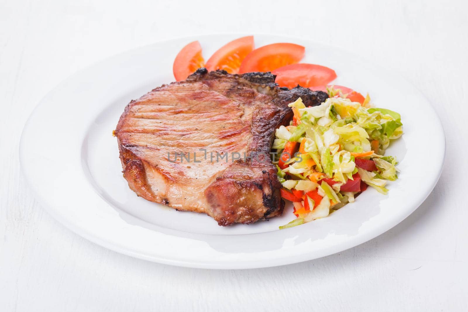 Grilled meat with spices on a white plate