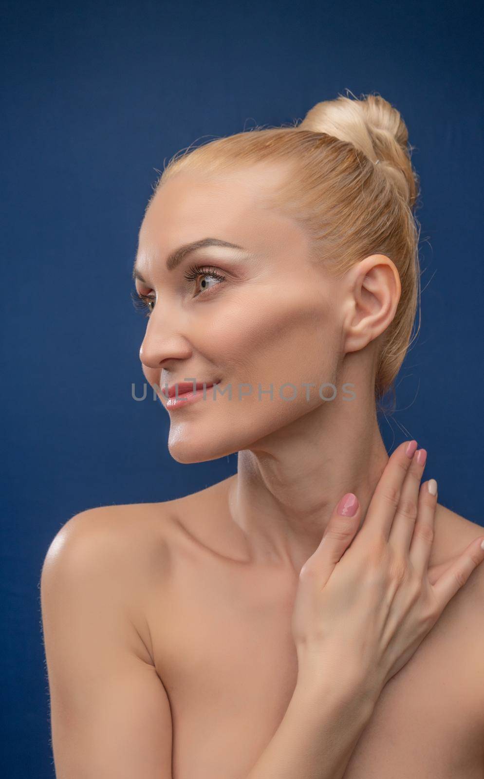 Happy young exhausted woman sitting on a chair, wonderful in a black suit with a European face on a blue background with daylight. Flaunts