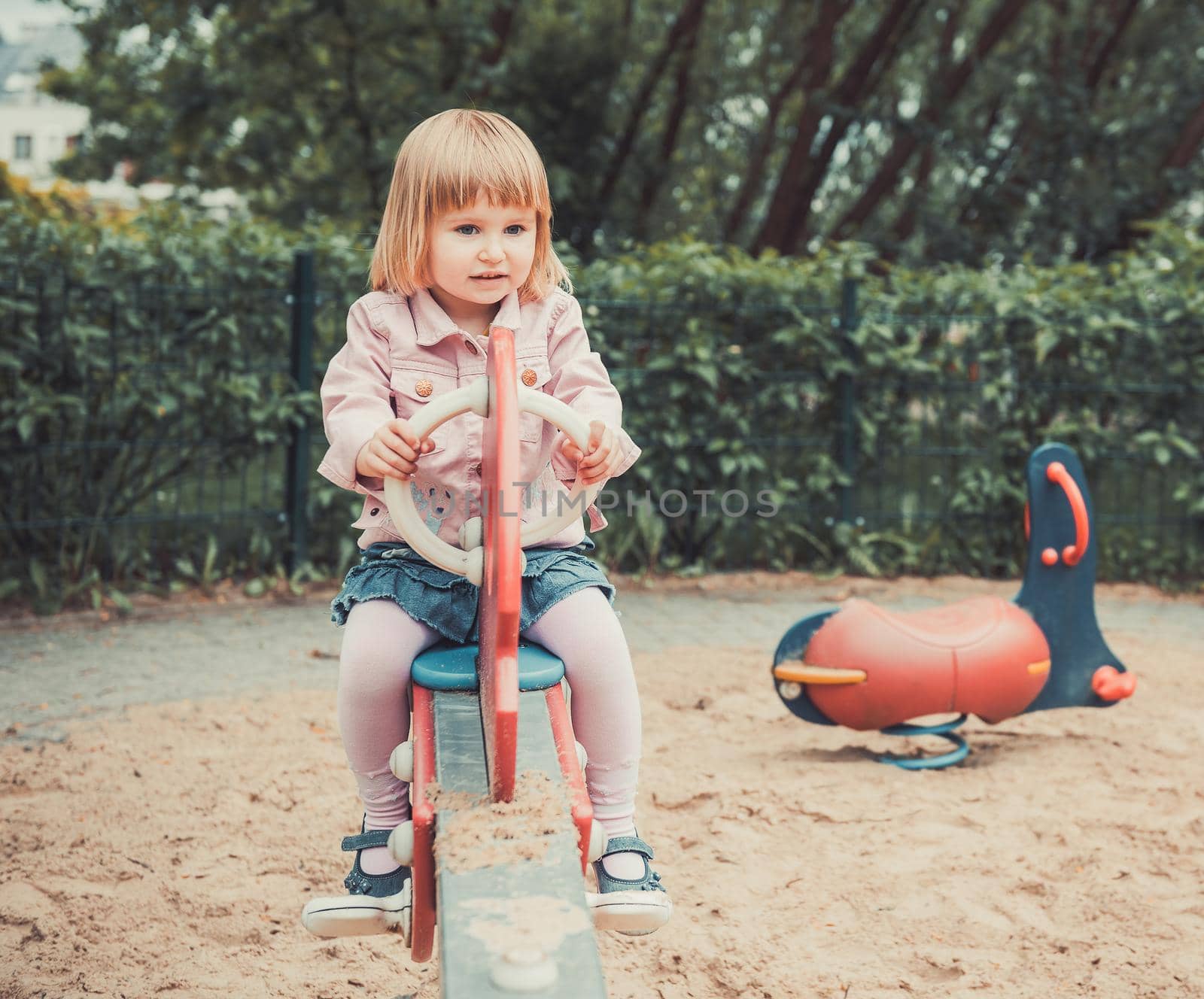 little girl on a swing on a playground