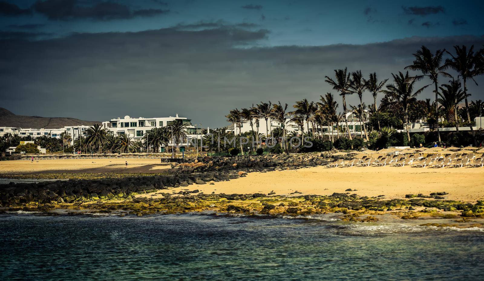 desert Lanzarote coast with a township on the background, Canary Islands, Spain